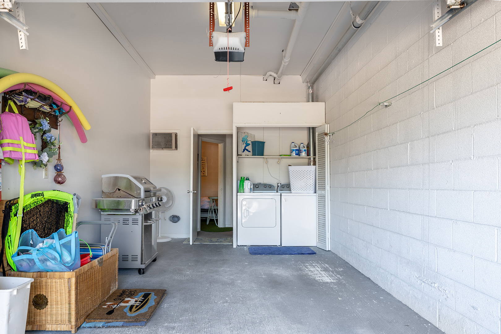 Garage with beach gear, a grill and laundry machines at Coral Shores 12