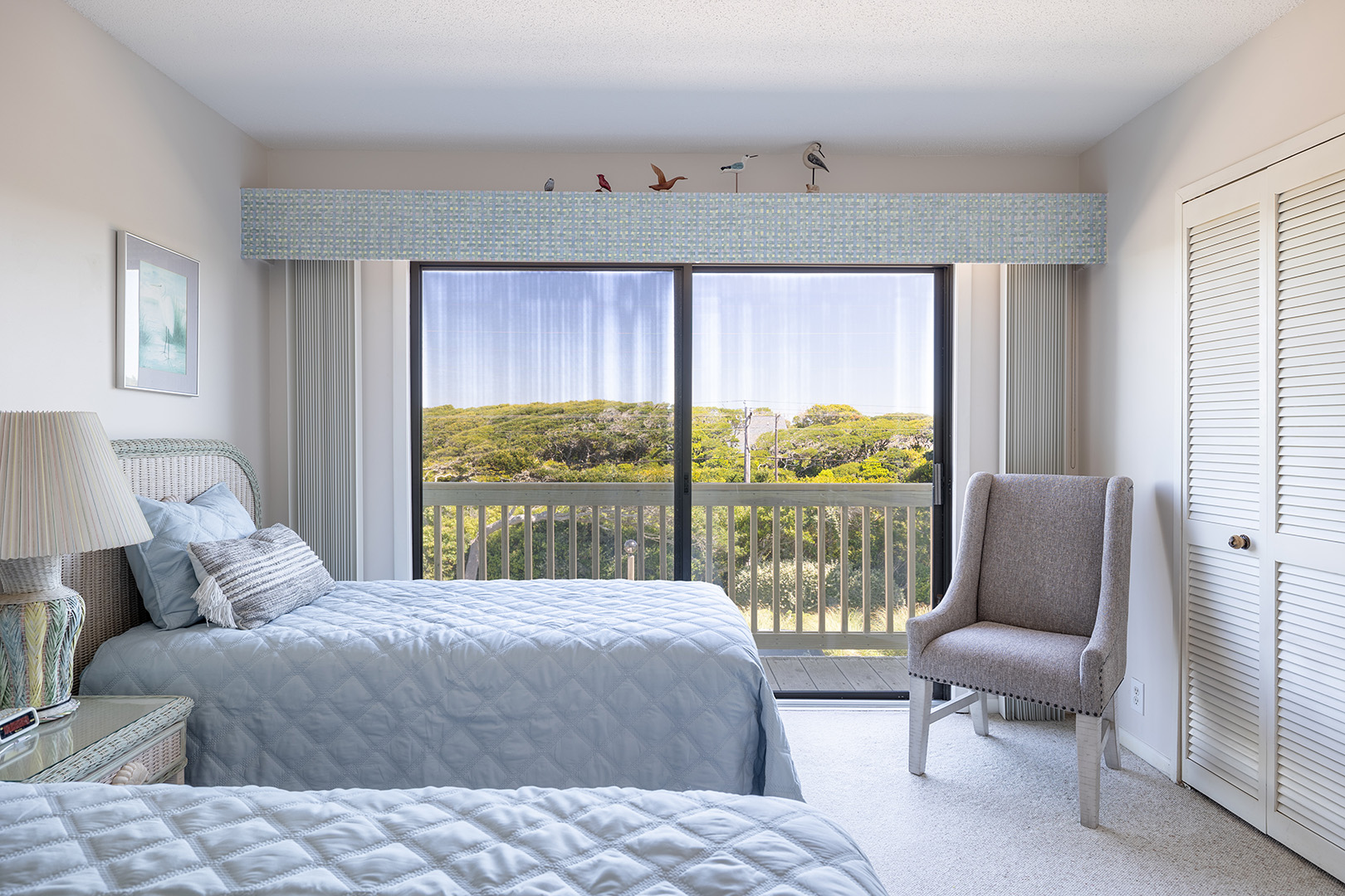 Bedroom with two beds and a balcony door at Coral Shores 12