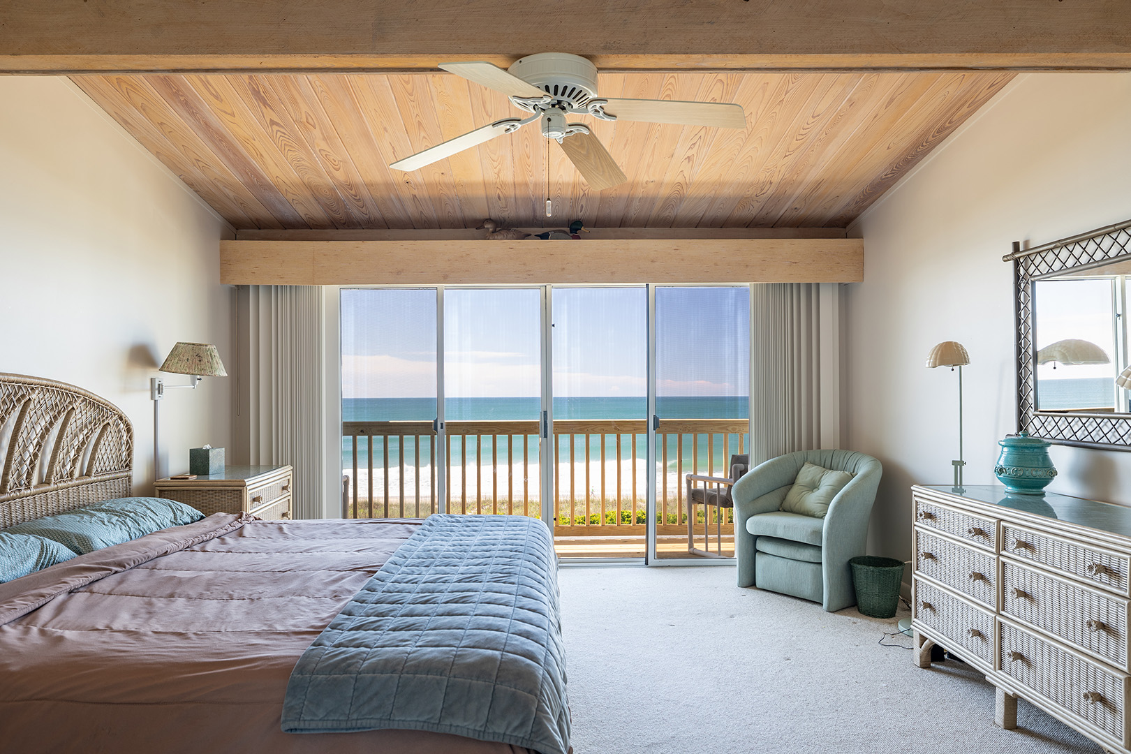 Primary bedroom with ocean view through sliding doors at Coral Shores 12