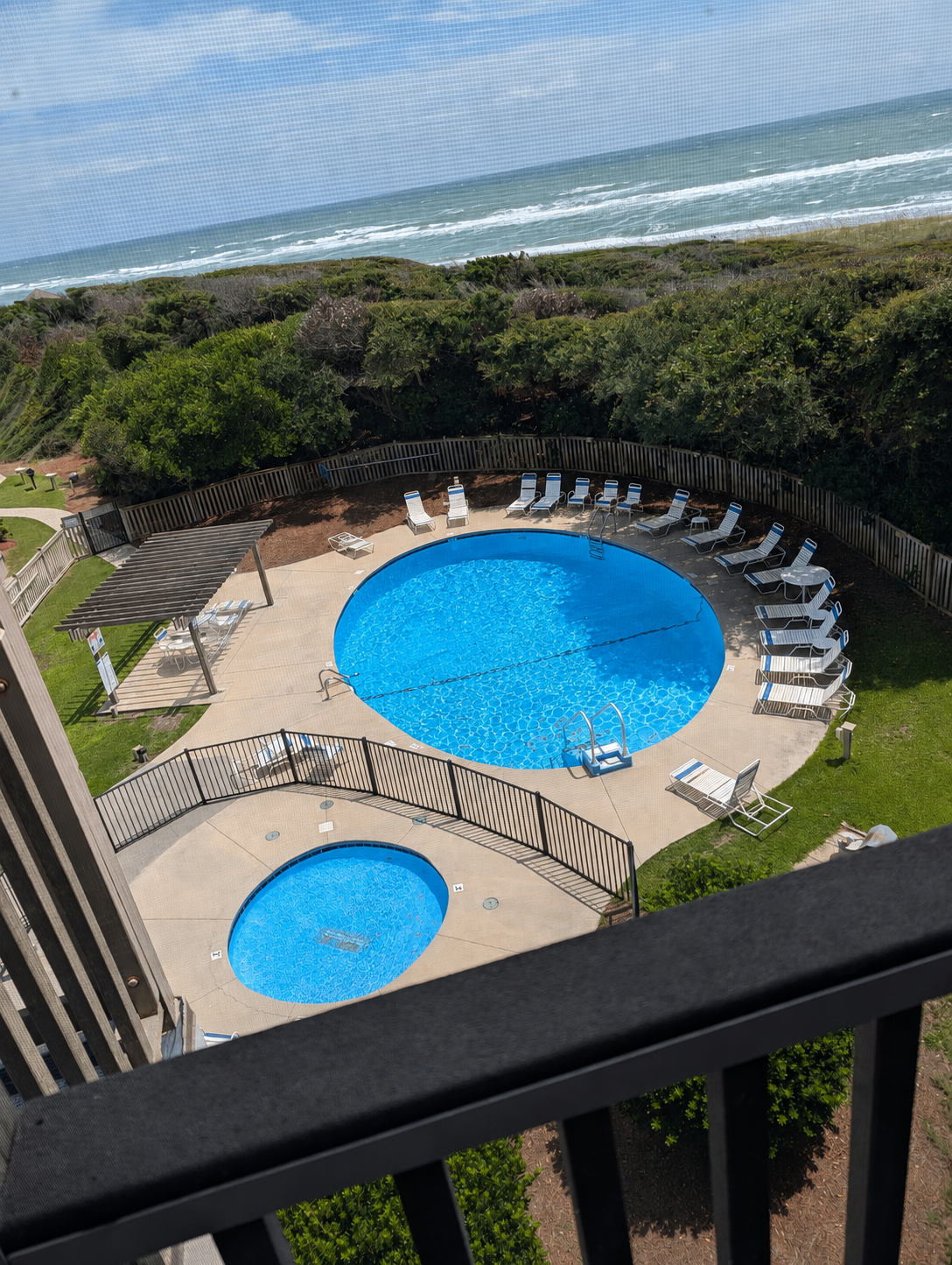Porch view over the oceanfront pool and kiddie pool, dunes and Atlantic Ocean at Island Beach & Racquet Club B302