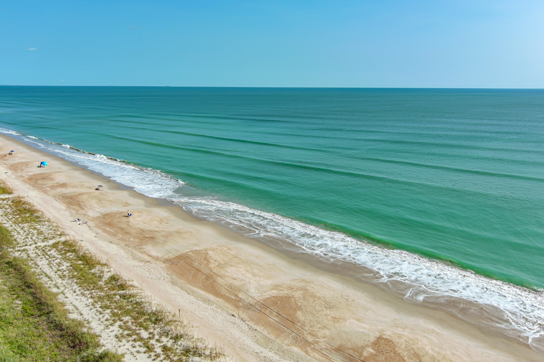 Aerial view of the turquoise shoreline in front of Coral Shores 12