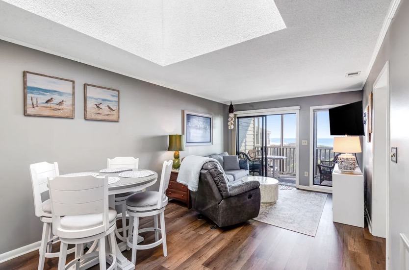 Dining and living area with an ocean view at Island Beach & Racquet Club B302