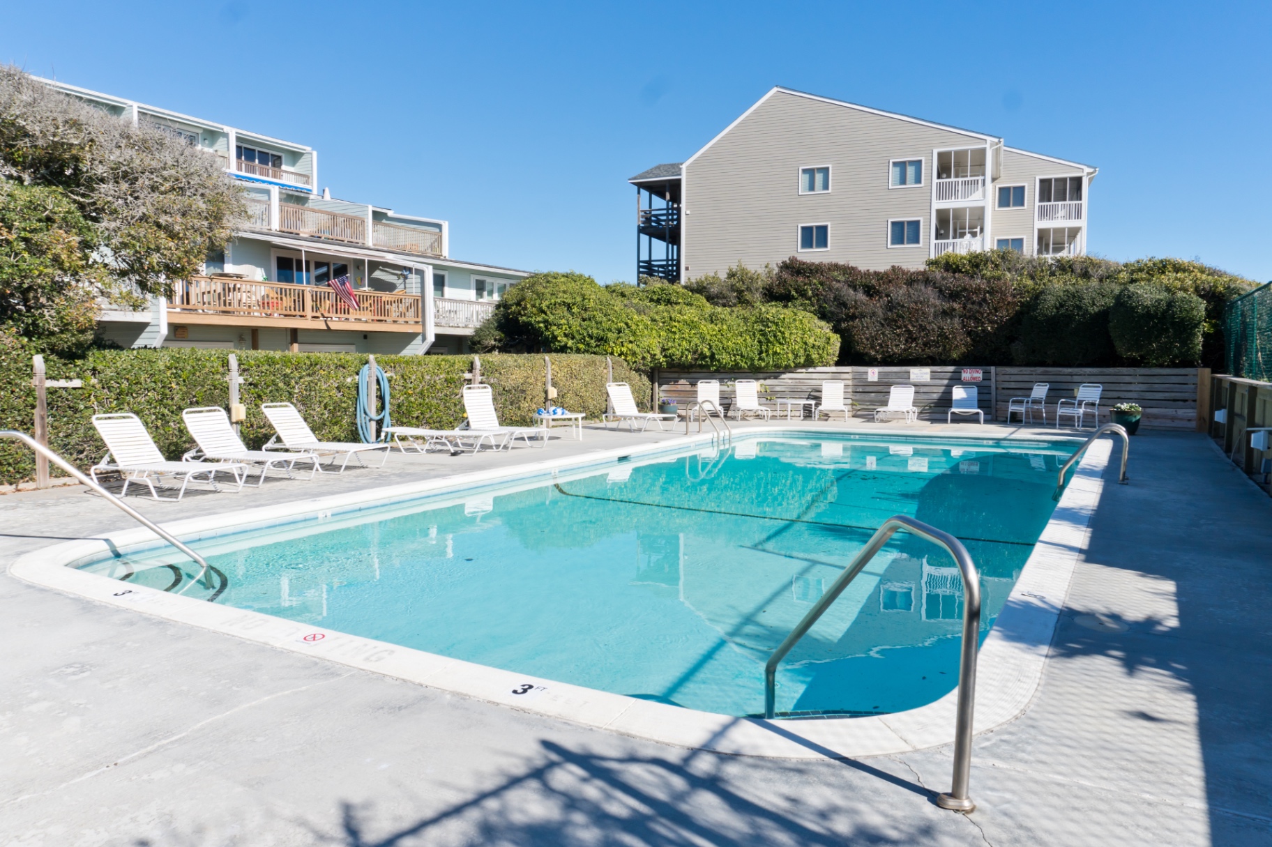 Community pool and lounge chairs at Coral Shores 12